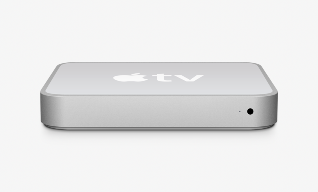 A realistic rendering of the first Apple TV, a small silver box with a white Apple logo and the word 'tv' on it.